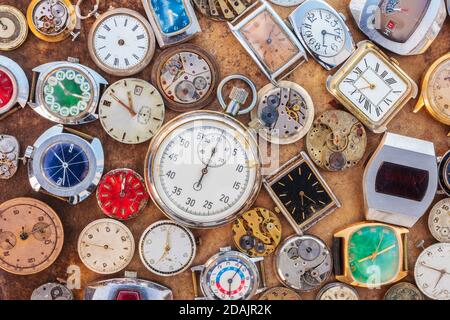 Collection of vintage rusty watches and parts on a brown old rusted background Stock Photo