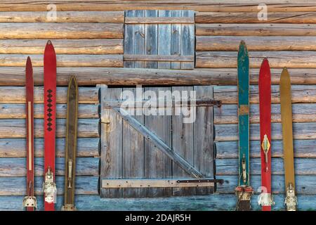 Collection of vintage wooden weathered ski's in front of an old barn Stock Photo