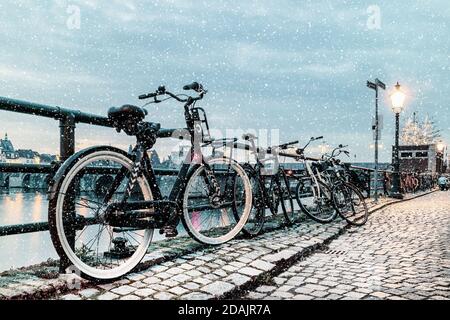 Winter view of parked bicycles alongside the Dutch river Maas in the city of Maastricht Stock Photo