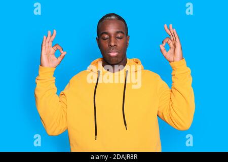 Portrait of one young african black man relaxes after hard working day, he is performing yoga. Stock Photo