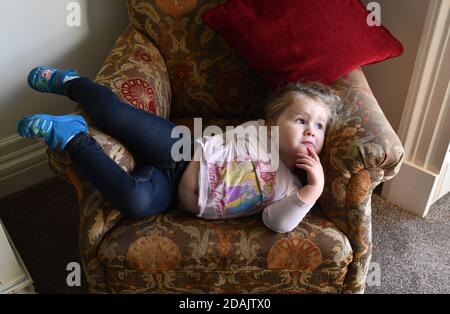 Cute child toddler girl looking towards window and day dreaming Stock Photo