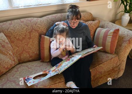 Grandmother reading to grandchild Britain Uk Stock Photo