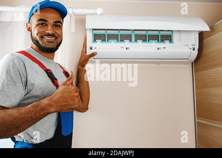 Professional repairman installing air conditioner in a room Stock Photo