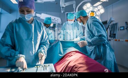 Surgical team in blue medical suits using medical instruments and ...