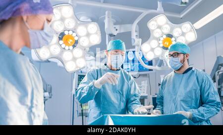 Diverse Team of Professional surgeon, Assistants and Nurses Performing Invasive Surgery on a Patient in the Hospital Operating Room. Surgeons Have Stock Photo