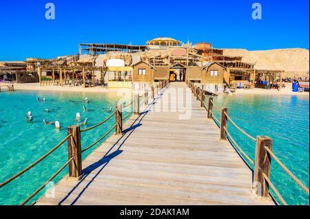 Wooden Pier at Orange Bay Beach with crystal clear azure water and white beach - paradise coastline of Giftun island, Mahmya, Hurghada, Red Sea, Egypt Stock Photo