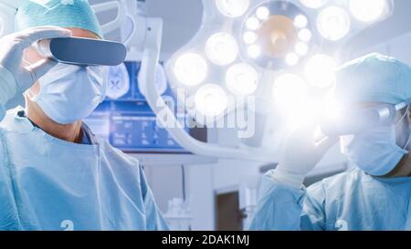 Surgeons Put on Augmented Reality Glasses to Perform State of the Art Surgery in High Tech Hospital. Doctors and Assistants Working in Operating Room. Stock Photo