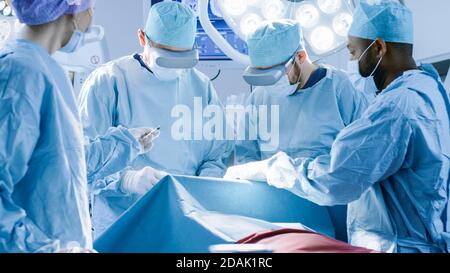 Surgeons Wearing Virtual Reality Glasses to Perform State of the Art Surgery in Technologically Advanced Hospital. Doctors and Assistants Working in Stock Photo