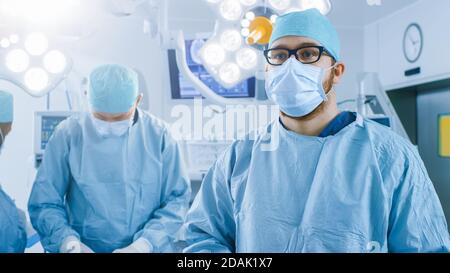 In the Operating Room Surgeon Gestures Using Augmented Reality Technology During Operation. In the Background Assistants and Nurses Working with Real Stock Photo