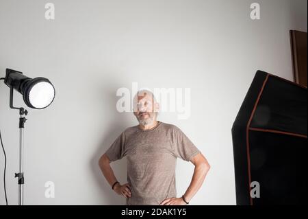 Self-employed senior photographer without digital camera in his photo studio Stock Photo