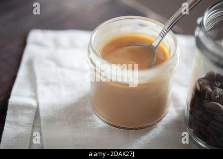 Coffee-flavored yogurt pudding dessert in glass jar close-up. Healthy lifestyle, superfood Stock Photo
