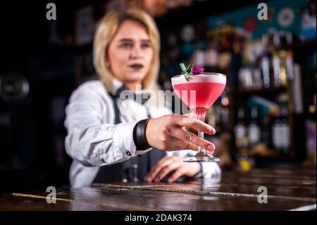 Girl bartender mixes a cocktail in the alehouse Stock Photo