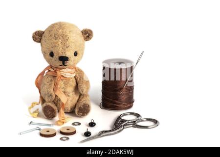 Small vintage handmade teddy bear on a white background. Hobby, materials for needlework. Handmade gifts and surprises for any occasion. Copy space. Stock Photo