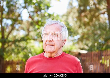 Senior man as a pensioner in the garden or on an excursion Stock Photo