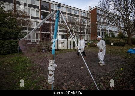 Roehampton, Southwest London, UK. 13th Nov 2020. Outdoor sports during Coronavirus Lockdown #2, Roehampton, Southwest London, UK Local Punjabi residents play badminton outside their block of flats in Roehampton during the Coronavirus Lockdown #2 on a sunny Autumn afternoon, Southwest London, England United Kingdom Credit: Jeff Gilbert/Alamy Live News Stock Photo