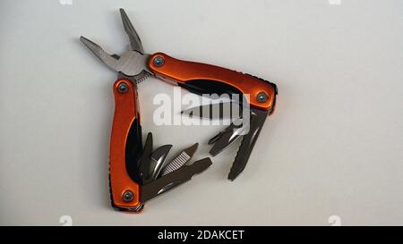 Pliers, multifunctional with functional tools, for use at home, in orange color with white background, copy space, side view, open Stock Photo