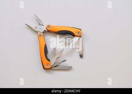 Pliers, multifunctional with functional tools, for use at home, in orange color with white background, copy space, side view Stock Photo