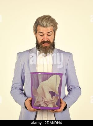 Office worker digging in garbage bin. Recover document. Destroy evidence. Rummaging in trash. Recover files after deletion. Businessman hold trash can. Man look for lost document in paper bin. Stock Photo