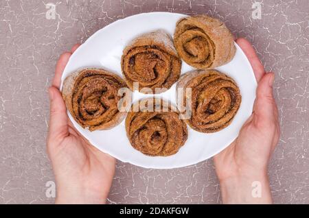 A step-by-step recipe for sweet cinnamon rolls. Step 12 - serving the baked cinnamon rolls Stock Photo
