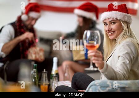 Portrait of a young happy american woman celebrating Christmas with friends Stock Photo