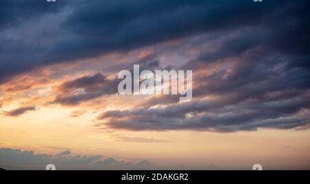 Sunset heavy dark clouds. Dramatic magical sunrise cloudscape over blue gray orange color cloudy sky Stock Photo
