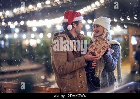 young caucasian couple in love enjoying christmastime, exchanging presents Stock Photo