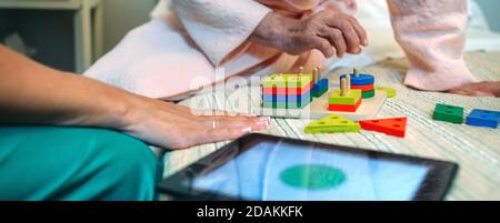 Female doctor showing geometric shapes to elderly patient Stock Photo