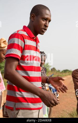 Selingue, Mali, 28th April 2015; Sory Sidibe, agricultural technician, (AT) for the Selingue advice team advising  Farmer Sekou Dumbia, (pink jacket). Stock Photo