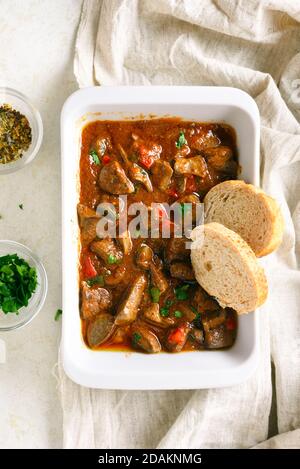 Peri-peri chicken livers in baking dish over light background. Top view, flat lay, close up Stock Photo