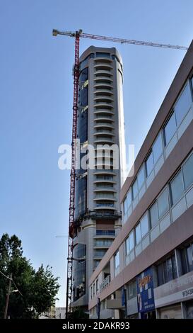 Modern skyscraper building with tall crane above nearing completion of construction, Nicosia, Cyprus Stock Photo
