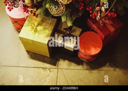 Gift boxes under christmas tree.Many Christmas gifts on floor under fir tree. New Year tree with balls, boxes with gifts stand next to it. wonter Stock Photo