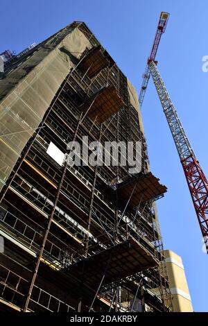 Modern skyscraper building with tall crane above under construction in 2020 with work platforms on side, Nicosia, Cyprus Stock Photo