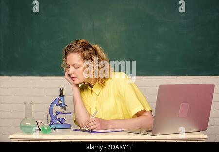 Wisdom. scientist at school lab. biology experiment research. make notes about chemistry research results. working student with microscope and beaker. girl in classroom laboratory with computer. Stock Photo