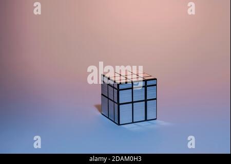 Mirror Silver Rubik's Cube on pink and blue gradient background, Magic Cube, Puzzle Cube Stock Photo