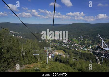 People travelling on a chairlift, summer Aerial view of Harrachov town (Harrachov, Czech republic) Stock Photo