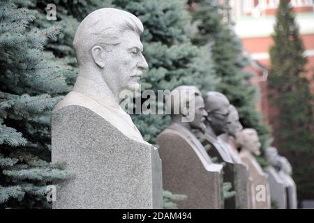 = Stalin and Other Soviet Leaders =  Side angle view on the light grey marble bust of Stalin and other Communist party leaders and renowned military c Stock Photo