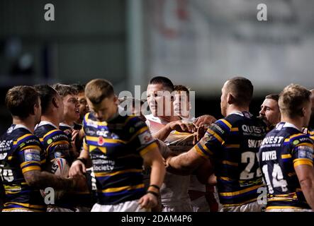 Leeds Rhinos' Rhyse Martin (centre) and Catalans Dragons' Tom Davies clash during the Betfred Super League Play-Off match at The Halliwell Jones Stadium, Warrington. Stock Photo