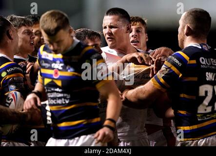 Leeds Rhinos' Rhyse Martin (centre) and Catalans Dragons' Tom Davies clash during the Betfred Super League Play-Off match at The Halliwell Jones Stadium, Warrington. Stock Photo