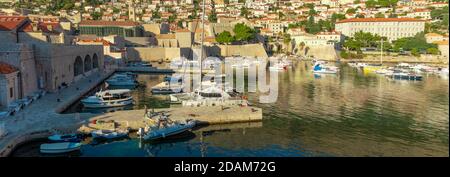 Dubrovnik Croatia November 2020 Bay area of the Dubrovnik town, small boats anchored in the harbour. Old city walls surrounding the port in the famous Stock Photo