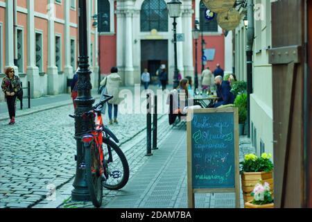 Wroclaw, Poland - May 10, 2019: Tourist dining in the busy street of Polish old town in the main city center. A black board with special menu of the d Stock Photo