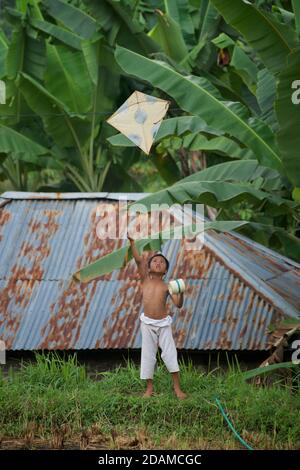 Candid photograph of an Indonesian boy flying a kite, Lombok, Indonesia Stock Photo