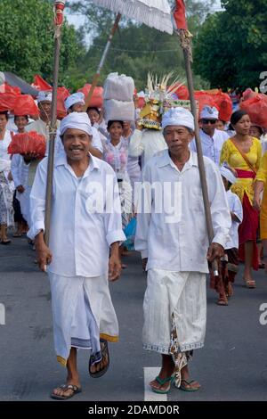 Balinese men in traditional white attire, attending Galungan festivities, Sakenan temple, Bali, Indonesia Stock Photo