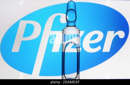 In this photo illustration an ampule seen in front of American multinational pharmaceutical corporation Pfizer logo. Stock Photo