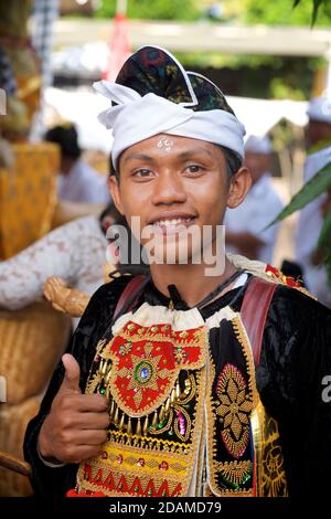 Young Balinese man in festive dance wear for temple ceremonial dance, Sakenan temple, Bali, Indonesia Stock Photo