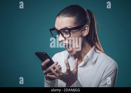 Angry stressed businesswoman shouting on the phone, she is nervous and disappointed Stock Photo