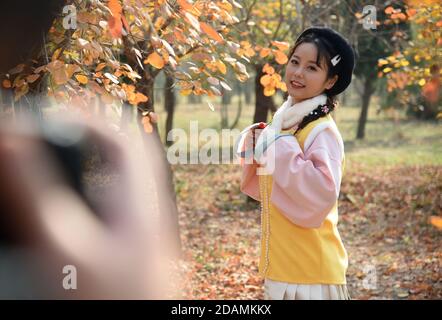 (201114) -- HEZE, Nov. 14, 2020 (Xinhua) -- Sun Yan, an online clothes store owner, poses for photos with the costume she designed in the fusion of the traditional clothing of the Han ethnic group that is generally called Hanfu, in Sunzhuang Village in Caoxian County of Heze City, east China's Shandong Province, Nov. 10, 2020. Sunzhuang Village thrives on e-commerce business. Among some 760 households in the village, more than 560 run online clothes stores on Taobao.com, Alibaba's main e-commerce site. The village's sales volume of costumes exceeded 200 million yuan (about 30.22 million U.S. d Stock Photo