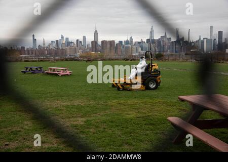 Beijing, USA. 12th Nov, 2020. A worker wearing personal protective equipment mows the grass at Bushwick Inlet Park in the Brooklyn borough of New York, the United States, Nov. 12, 2020. The United States reported 143,408 new COVID-19 cases Wednesday, a record daily increase since the onset of the pandemic in the country, the U.S. Centers for Disease Control and Prevention (CDC) said Thursday. Credit: Michael Nagle/Xinhua/Alamy Live News Stock Photo