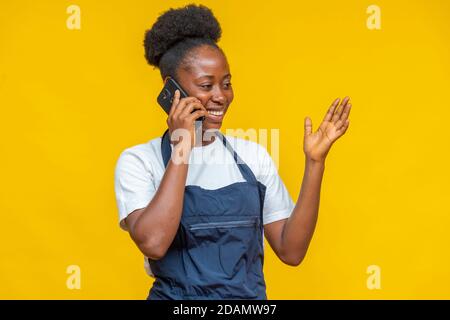 african woman wearing an apron making a phone call Stock Photo