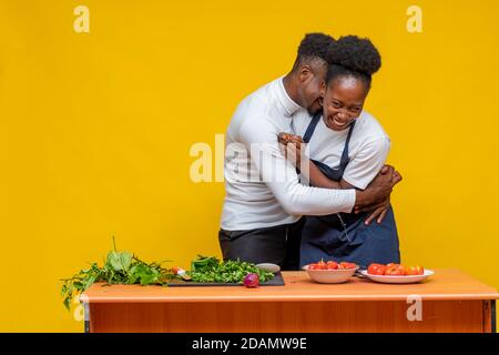 african couple cooking together playfully and having a laugh Stock Photo