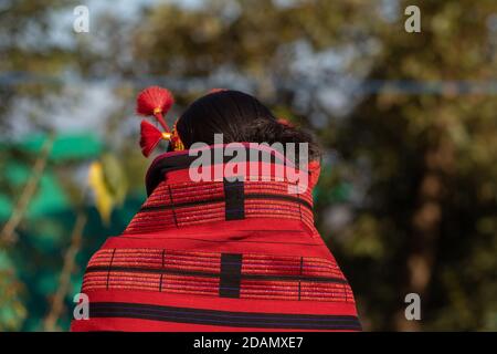 Abstract image of a traditional tribal Naga women from back wearing a traditional headgear an a red Naga shawl Stock Photo